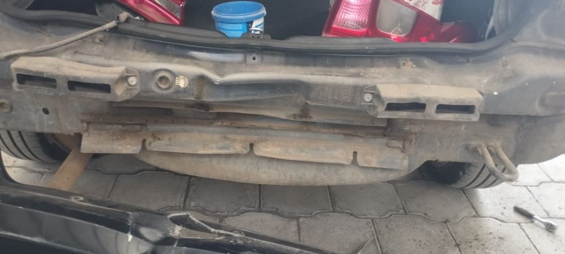 Zaga del vehiculo con la traviesa, los soportes del guardachoque y el faldon inferior al descubierto
