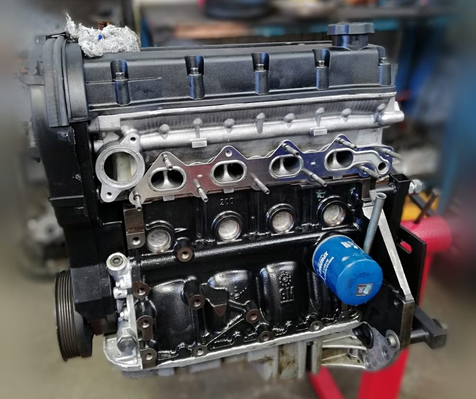 Motor completo recién reparado sobre el soporte de trabajo del taller, con el filtro de aceite nuevo