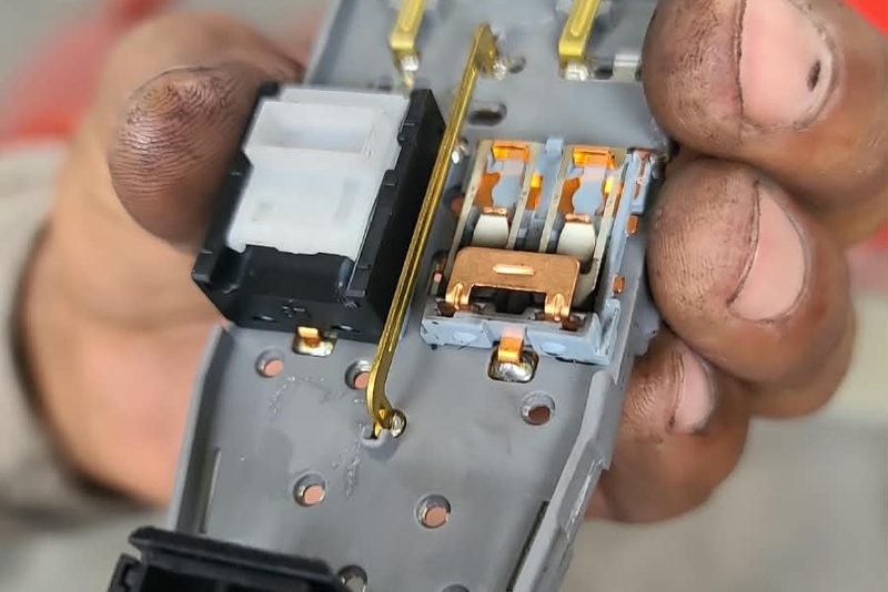 Técnico sosteniendo en la mano el módulo eléctrico desmontado de un vehículo
